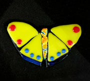 Bright yellow glass butterfly red and blue spots