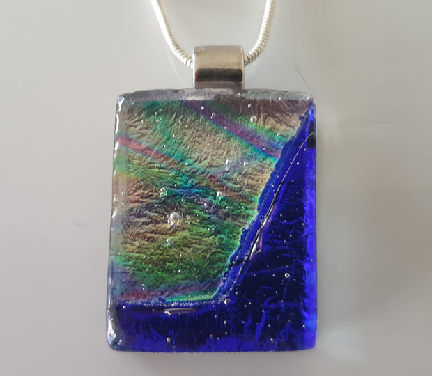 small blue pendant with multicoloured dichroic glass